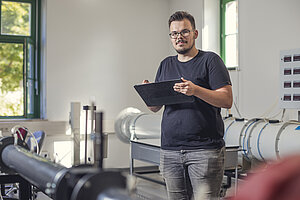 Robert Prigge steht mit Tablet im Labor