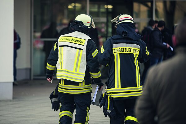 Zwei Feuerwehrleute von hinten zu sehen