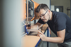 Robert Prigge arbeitet an einer Maschine im Labor